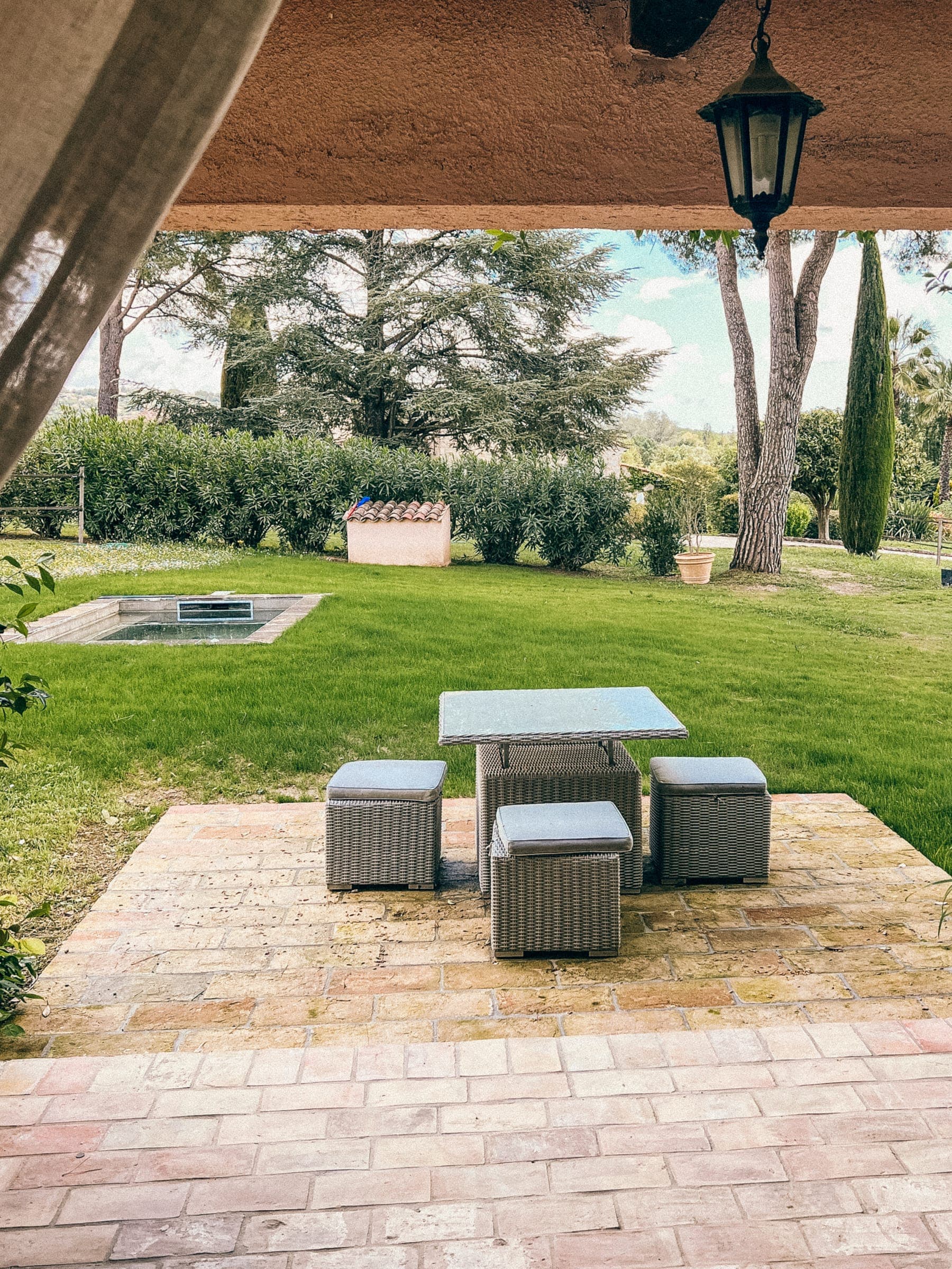 Shaded outdoor seating with a table on the terrace facing the garden